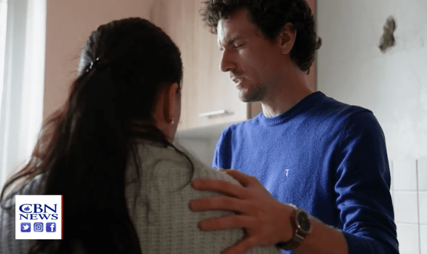 O tenista russo Artem ora com refugiada ucraniana. (Captura de tela CBN News)