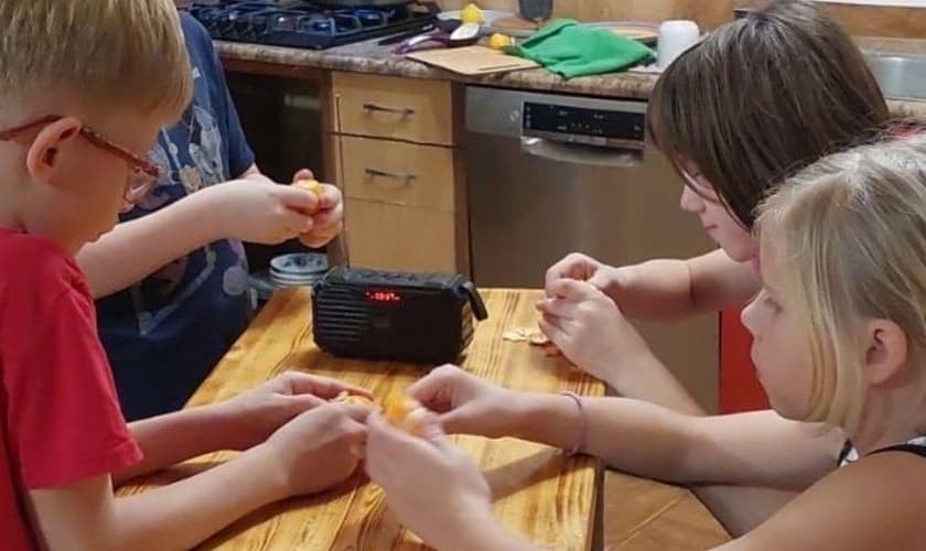 Crianças da Bielorrússia se reúnem em torno de um rádio para ouvir a programação infantil da TWR. (Foto cortesia dos contatos da TWR).