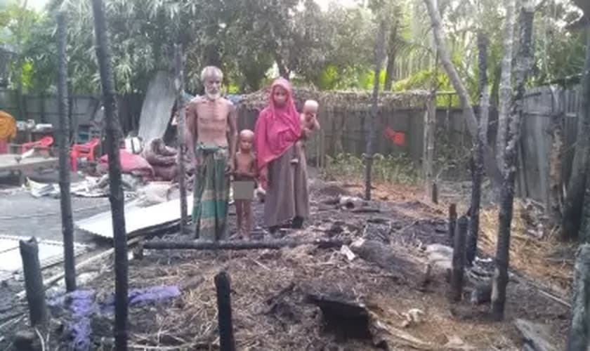 Família diante da casa incendiada. (Foto: Open Doors)