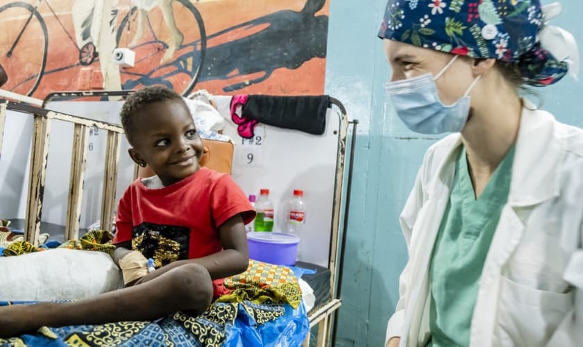 A voluntária médica Anna Leigh Breedlove brinca com uma criança na ala pediátrica do Baptist Medical Center de Nalerigu, Gana. (Foto: IMB).