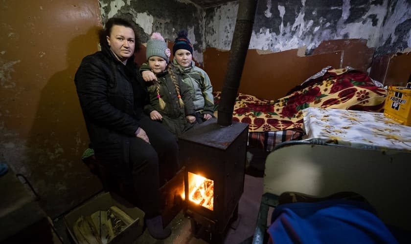 Olena e seus filhos em seu porão com o fogão doado pela Samaritan’s Purse. (Foto: Samaritan’s Purse).