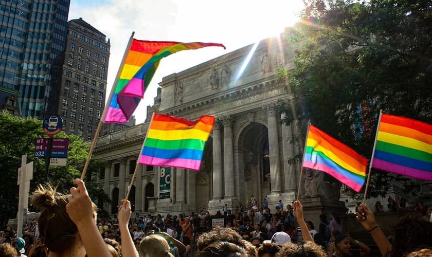 Pessoas carregam a bandeira utilizada como símbolo LGBT. (Foto: Pixabay)