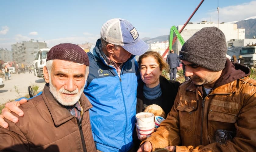 Família afetada pelo terremoto com missionários locais. (Foto: Ilustração/Send Relief)