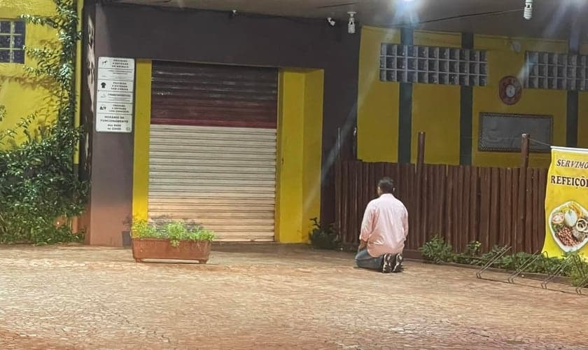 Ademir ajoelhado em frente a sua padaria em SP. (Foto: Reprodução/Facebook/Juliana Balbi)