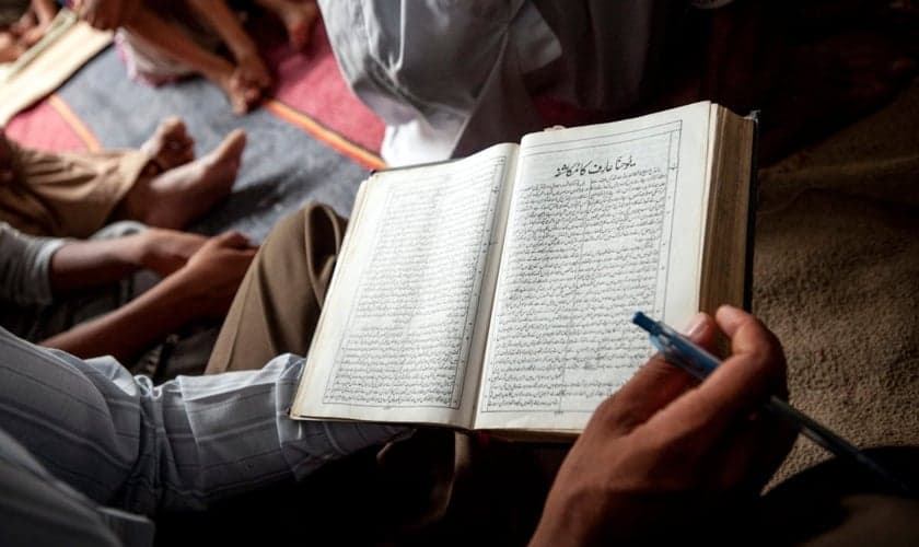 Um cristão paquistanês lê sua Bíblia durante um culto de domingo de manhã na igreja de uma comunidade ocupada. (Foto: IMB)