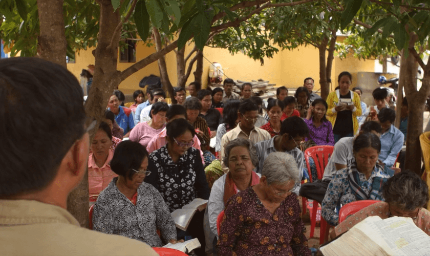 Cambojanos ouvem pregação da Palavra de Deus em terreno budista. (Captura de tela/Cambodia Christian Ministries)