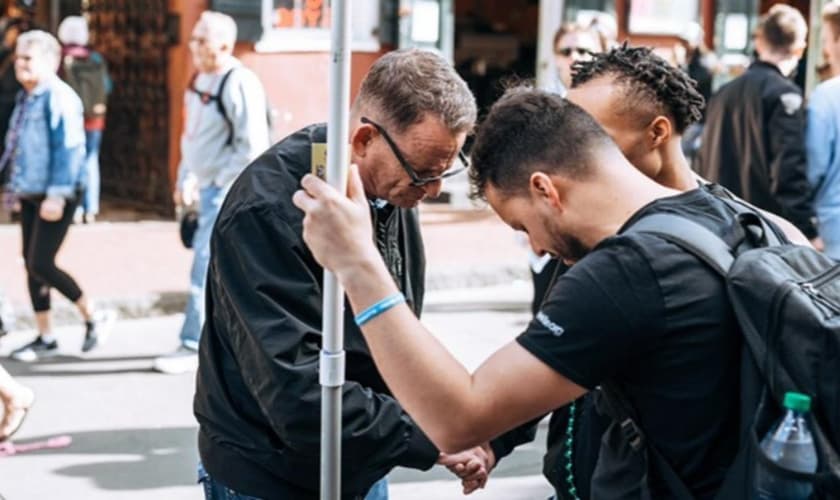 Scott orando pelos jovens nas ruas. (Foto: Reprodução/AG News)