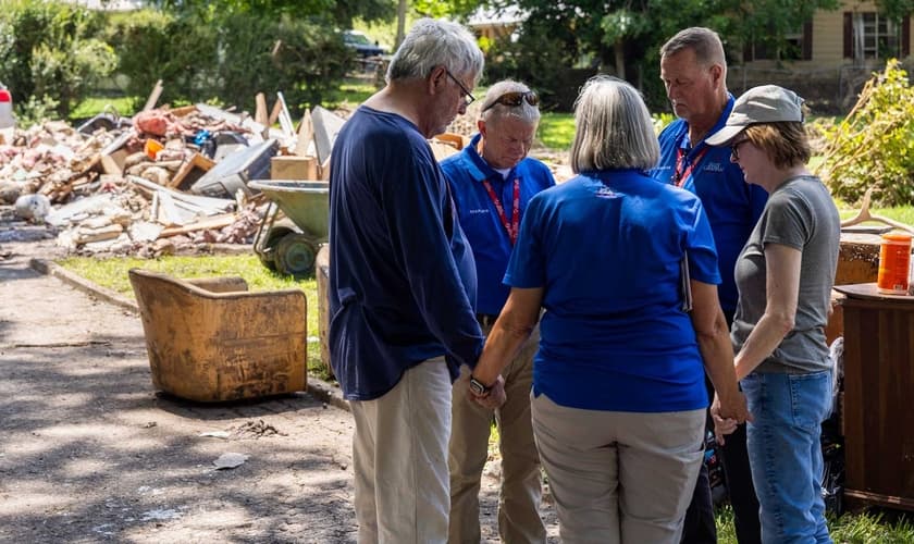 Integrantes da Associação Evangelística Billy Graham oram com sobrevivente da enchente no Texas. (Foto: Associação Billy Graham)