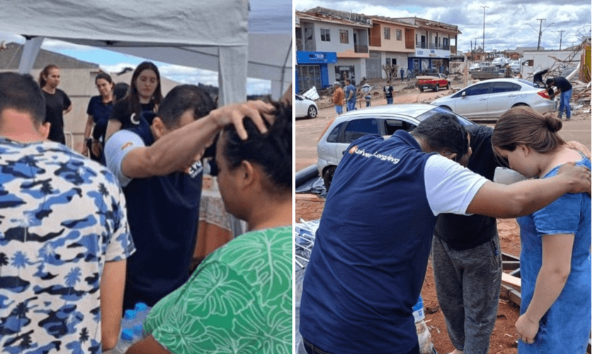 Moradores recebem oração em tenda montada por igreja em Rio Bonito do Iguaçu. (Foto: Universal)